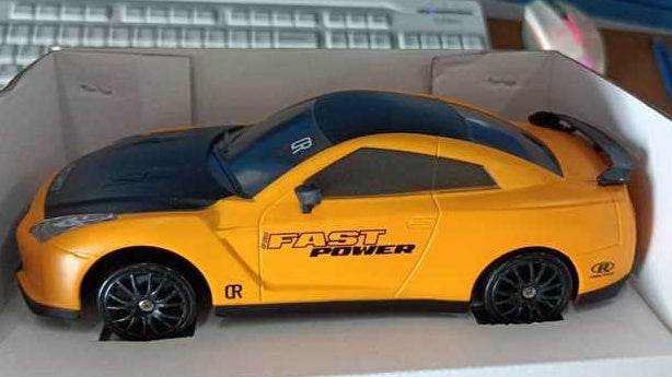 4WD RC Drift Car in orange and black plastic with racing decals, dark windows and black multi-spoke wheels