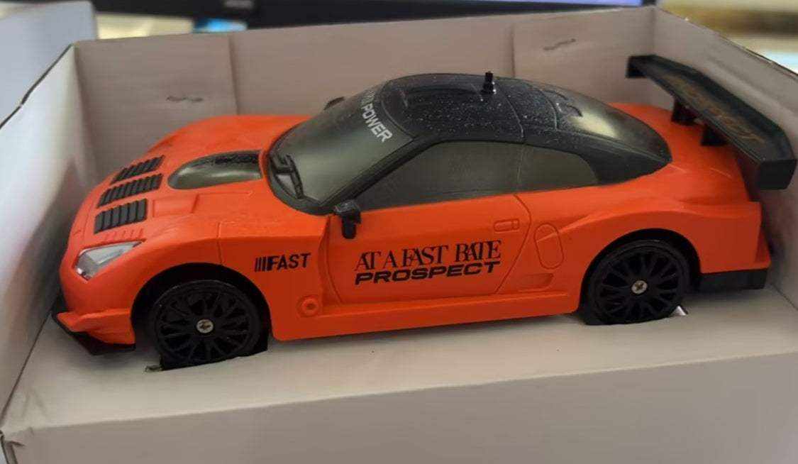 4WD RC Drift Car with an orange body, black roof and spoiler, dark wheels, and racing decals