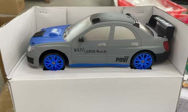 4WD RC Drift Car in silver with blue hood and wheels, black rear spoiler, and racing decals on a four-door body
