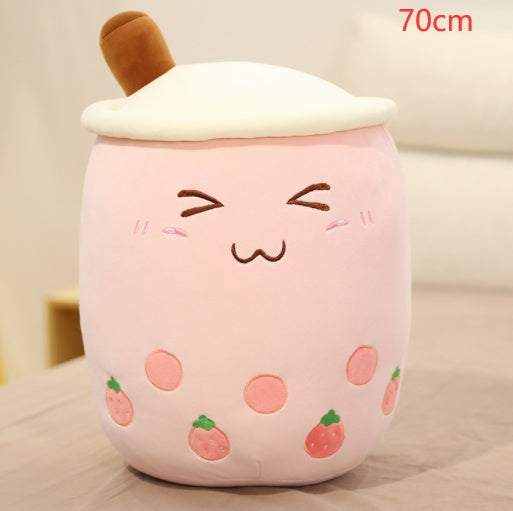Bubble Tea Plush Pillow in pale pink plush with cream topping, brown straw, embroidered face and strawberry details