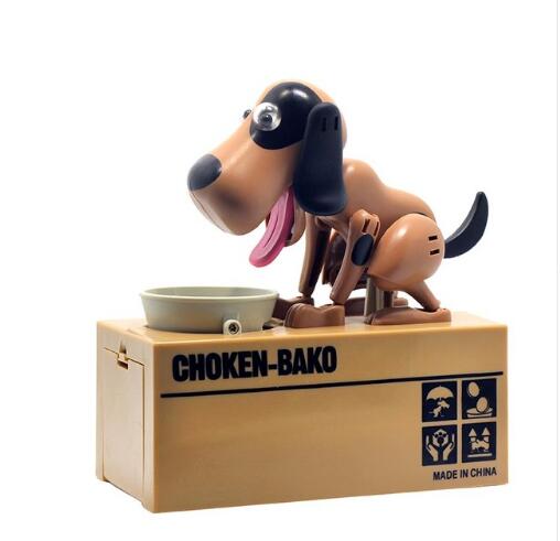 Robotic Dog Piggy Bank in tan plastic with black ears and tail, pink tongue, standing beside a coin bowl