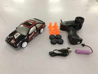 4WD RC Drift Car in black with red racing decals, white wheels, and a remote, spare tires, cones, and accessories