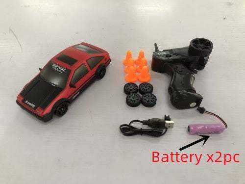 4WD RC Drift Car in red and black with a remote controller, spare wheels, orange cones, USB cable and two batteries