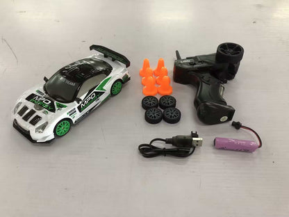 4WD RC Drift Car with a white and green racing livery, black spoiler, green wheels, remote, spare tires and cones