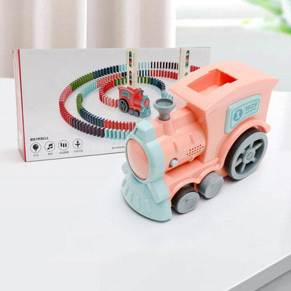 Automatic Domino Train Toy in coral pink and pale blue plastic, with chunky wheels and a matching box showing colorful dominoes