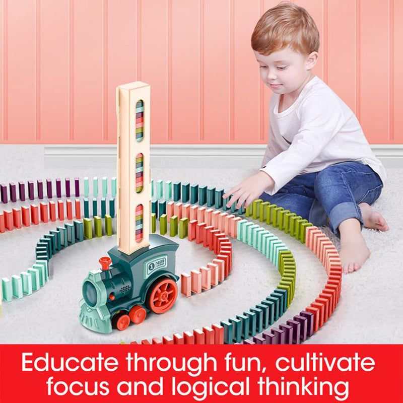 Automatic Domino Train Toy with a mint green and orange plastic locomotive placing multicoloured dominoes in winding rows