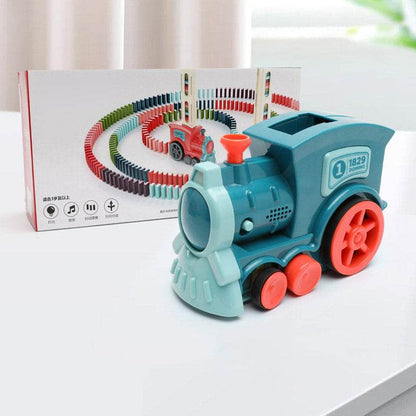 Automatic Domino Train Toy in teal plastic with bright red wheels, a smokestack and hopper, pictured with dominoes