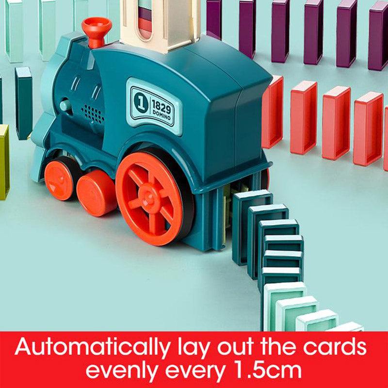 Automatic Domino Train Toy in teal plastic with bright red wheels, laying dark and white dominoes in a neat row