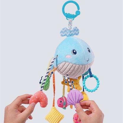 Baby Car Seat Hanging Toy in blue whale plush fabric with striped details, colorful dangling shapes and a turquoise clip