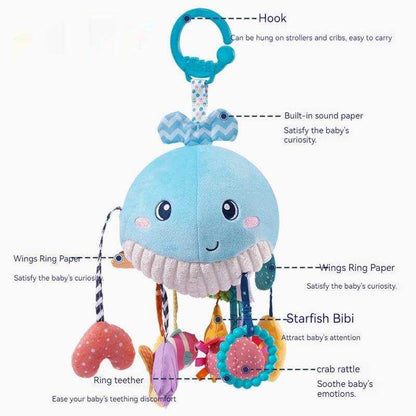 Baby Car Seat Hanging Toy in soft blue fabric with a smiling whale, patterned bow, hanging ribbons, ring teether and colorful rattles