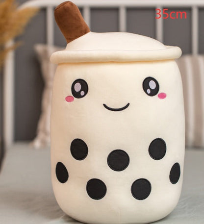 Bubble Tea Plush Pillow in cream plush fabric, with a brown straw, smiling embroidered face, and black tapioca pearls