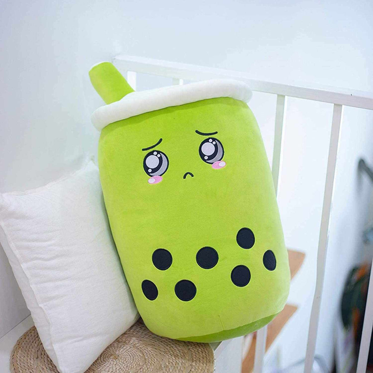 Bubble Tea Plush Pillow in bright lime green plush fabric, with a white lid, green straw, embroidered face and black tapioca dots
