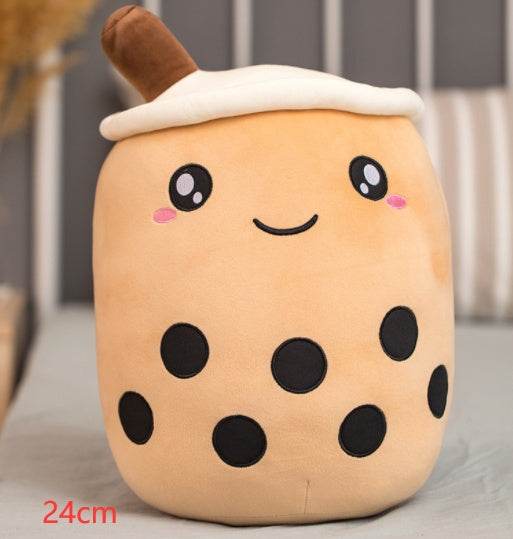 Bubble Tea Plush Pillow in peach-colored soft plush, with a white whipped topping, brown straw, embroidered smile and black tapioca pearls
