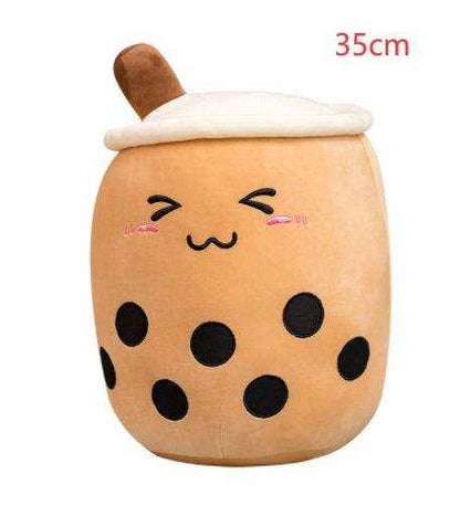 Bubble Tea Plush Pillow in tan short plush, shaped like a cup with a white lid, brown straw, black tapioca dots and embroidered face