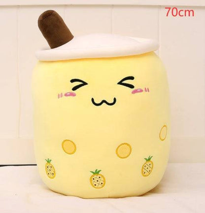 Bubble Tea Plush Pillow in pale yellow plush with a white lid, brown straw, embroidered smiling face and pineapple motifs