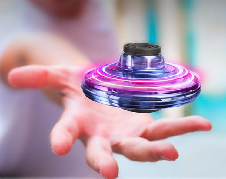LED Fingertip Gyro Spinner Toy with a transparent blue body, glowing pink and blue rings, and a black top