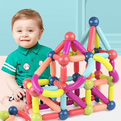 Magnetic Building Blocks Set with colorful plastic rods and balls forming a large geometric structure beside a toddler