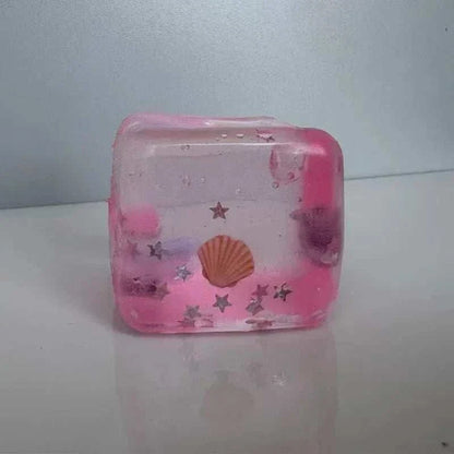 Squishy Ocean Fidget stress ball in translucent pink, with a seashell, glittering stars and small ocean-themed inclusions