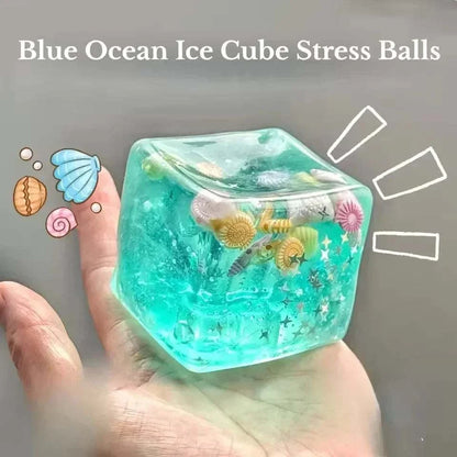 Squishy Ocean Fidget stress ball in translucent turquoise, with a clear cube shape and colorful seashell details inside